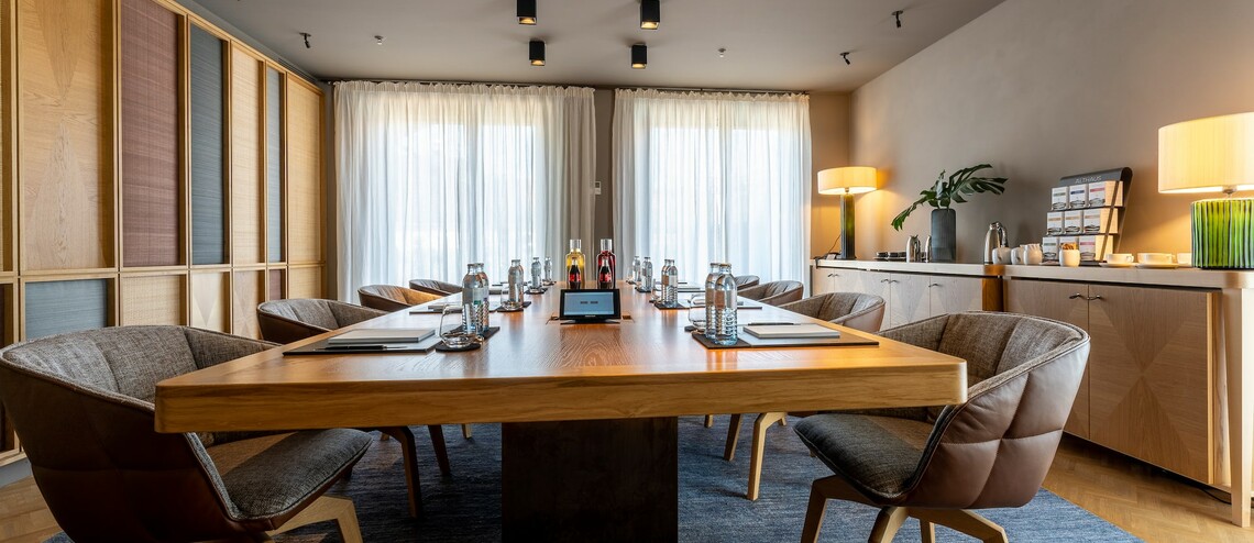 Besprechungsraum Boardroom mit großem Schreibtisch und Sesseln im LOUIS Hotel in München zu mieten