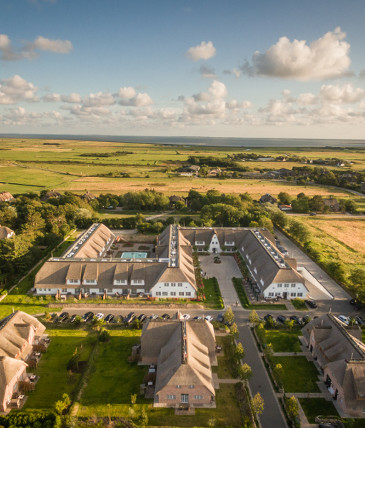 Luftaufnahme Hotel Severin*s auf Sylt Luftaufnahme des Severin*s Resort & Spa auf Sylt, umgeben von grüner Landschaft und malerischem Himmel.
