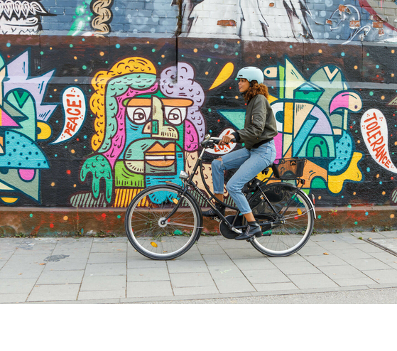 Graffiti in Munich Person on a bicycle in front of a colorful graffiti wall with the words "Peace" and "Tolerance".