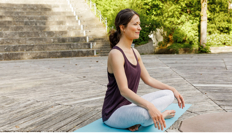 Woman sits on a yoga mat