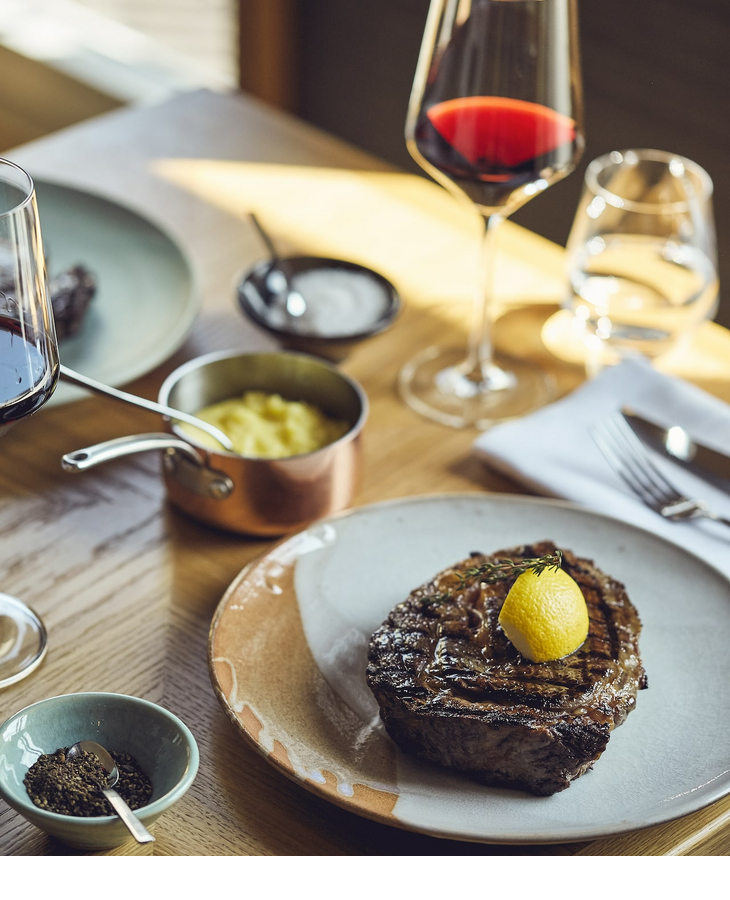 Steak und Rotwein auf einem Tisch im Grillroom Restaurant im LOUIS Hotel Muenchen