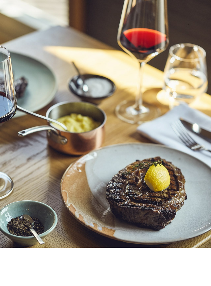 Steak und Rotwein auf einem Tisch im Grillroom Restaurant im LOUIS Hotel Muenchen